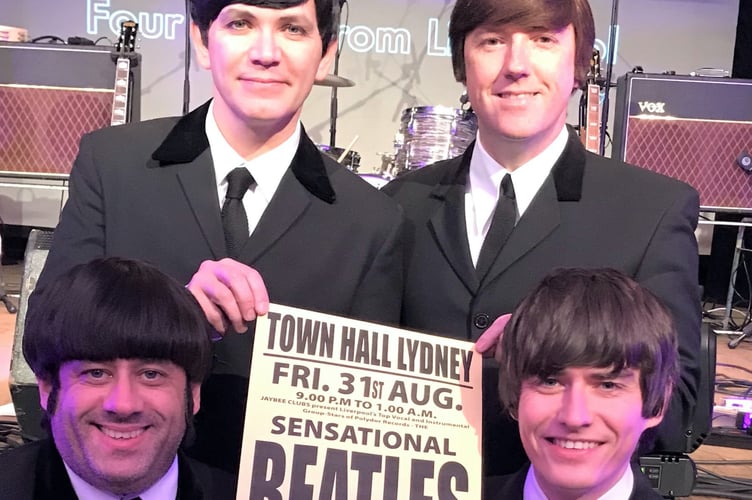 The Mersey Beatles band holding a poster advertising their Lydney Town Hall gig