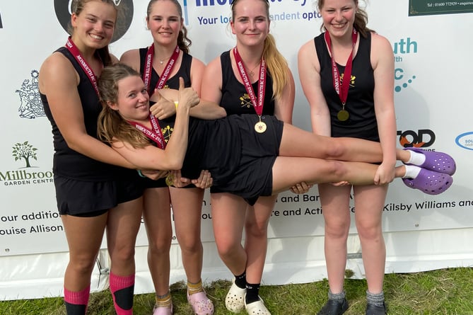 A winning crew celebrates by holding up their steerswoman. 