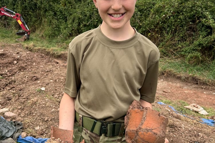 Cadet Joseph Callaghan, age 12, from Lydney Platoon, holds pieces of the 2nd Century cup and dog jawbone