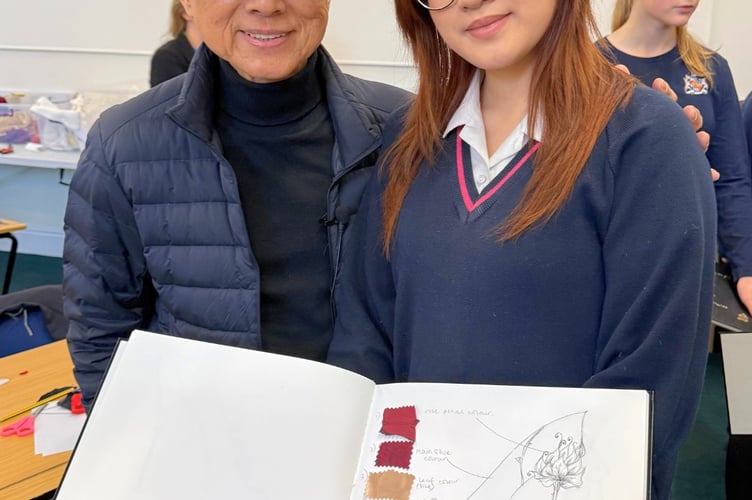 A pupil shows her design to Jimmy Choo